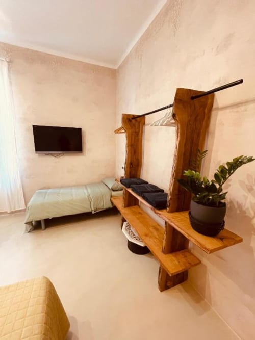 Lussuosa Camera Tripla a Casa Città Brescia con armadio in legno, letto, TV, pianta in vaso e pavimento in marmo