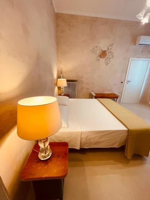 Camera Deluxe Tripla a Casa Città, Brescia - letto con lampada arancione e vista sulla corte interna