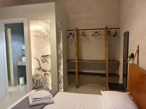 Camera doppia a Casa Città Brescia con letto, appendiabiti in legno, scaffalature e accesso al bagno en-suite