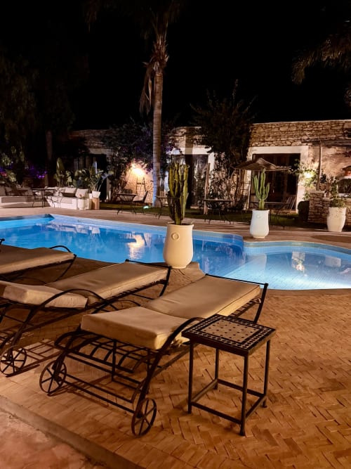 Piscine chauffée la nuit, Eucalyptus Ethnic Hotel, Essaouira. Transats, cactus, bâtiment en pierre, éclairage ambiant.