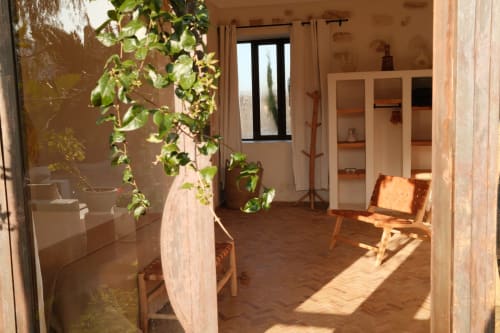 Chambre lumineuse de l'hôtel Eucalyptus Ethnic à Essaouira avec mobilier en bois, plantes en pot et décoration traditionnelle