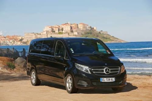 Monospace noir Mercedes sur la plage près de Porto-Vecchio avec la citadelle de Bonifacio en arrière-plan, transferts Villa Puccinelli