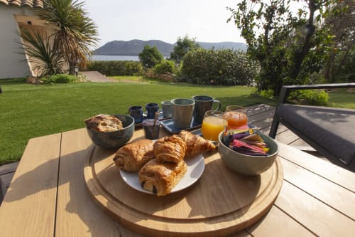 Petit-déjeuner à la Villa Puccinelli à Porto-Vecchio avec croissants, jus et vue sur la baie