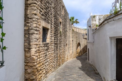 Estrecho callejón empedrado con muros de piedra en Casa De La Cruz Vejer, Vejer de la Frontera, España