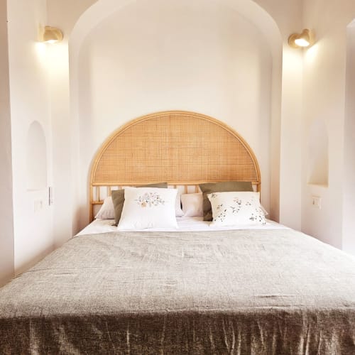 Dormitorio luminoso en Casa De La Cruz Vejer con cabecero de ratán, ropa de cama neutra e iluminación de acento en Vejer de la Frontera