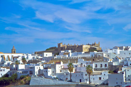Pueblo blanco de Casa De La Cruz Vejer: fortaleza histórica dominando tejados andaluces bajo cielo azul despejado