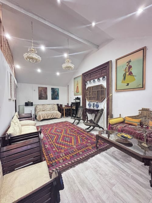 Elegant 2-bedroom annex bedroom in High Wycombe with traditional furniture, ornate rug, crystal chandeliers, and cultural