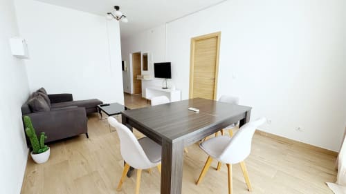 Apartamento moderno de planta abierta en DakarByDays Dakar con comedor, sofá gris, suelo de madera y luz natural