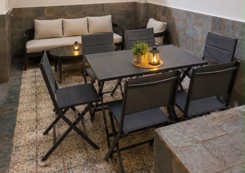 Patio exterior del Principe David Toledo con mesa de comedor, área de descanso y iluminación ambiental