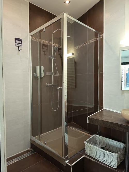 Salle de bain moderne avec carrelage foncé et pomme de douche effet pluie à la Maison D'hôtes Coeur D'hérault, Péret
