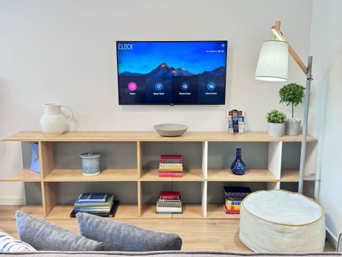Salon moderne à la Résidence Intelligente RIA CENTRUM à Aveiro avec TV murale, étagères en bois, plantes en pot et