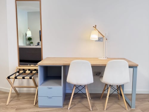 Espace de travail moderne à l'hôtel RIA CENTRUM Aveiro avec bureau en bois, chaises blanches, miroir et lampe de bureau