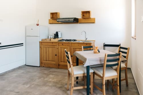 Wood apartment kitchen at Tenuta Fascianello with wooden cabinets, dining table, and modern appliances