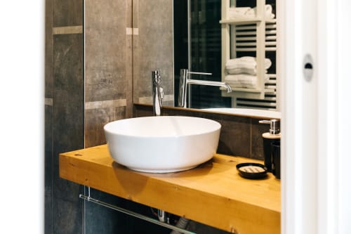 Modern bathroom vanity with white ceramic sink on yellow countertop at Tenuta Fascianello hotel in Fasano, Italy