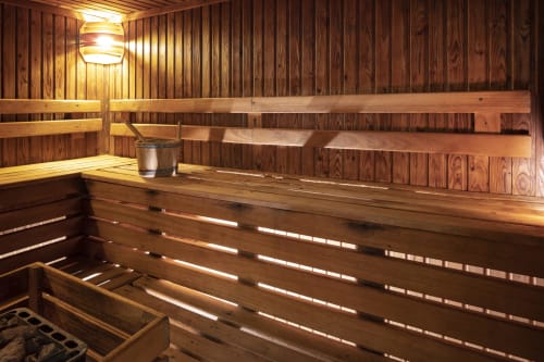 Intérieur de sauna en bois avec banquettes et éclairage d'ambiance à l'Hotel Residence Europe & Spa, Clichy