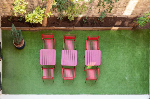 Aerial view of Hotel Residence Europe & Spa's garden courtyard in Clichy with pink loungers and red chairs on green