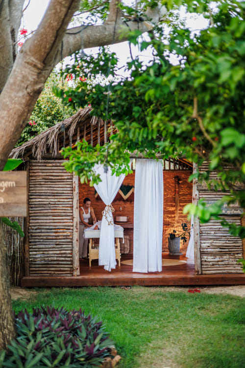 Bangalô rústico na La Cozinha Pousada, Cajueiro da Praia, com cortinas brancas e jardins exuberantes