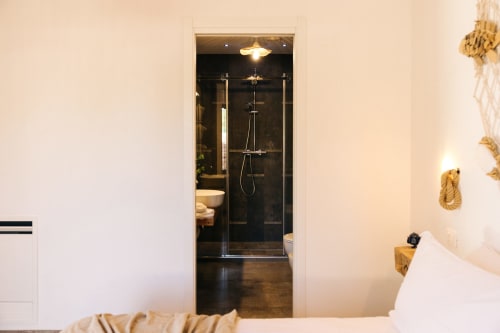 Modern bathroom with black tile shower and glass enclosure at Tenuta Fascianello in Fasano