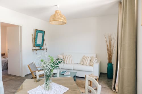 Bright garden view apartment at Tenuta Fascianello with white sofa, wooden furniture, and coastal decor in Fasano, Italy