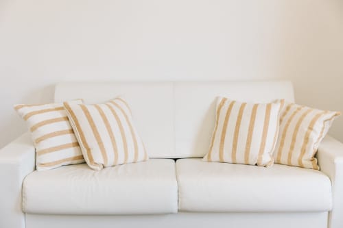 Cream sofa with gold striped cushions in Tenuta Fascianello Sea apartment, Fasano Italy