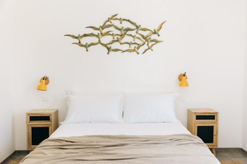 Camera minimalista a Tenuta Fascianello con comodini in legno, biancheria bianca e arte murale con rami dorati