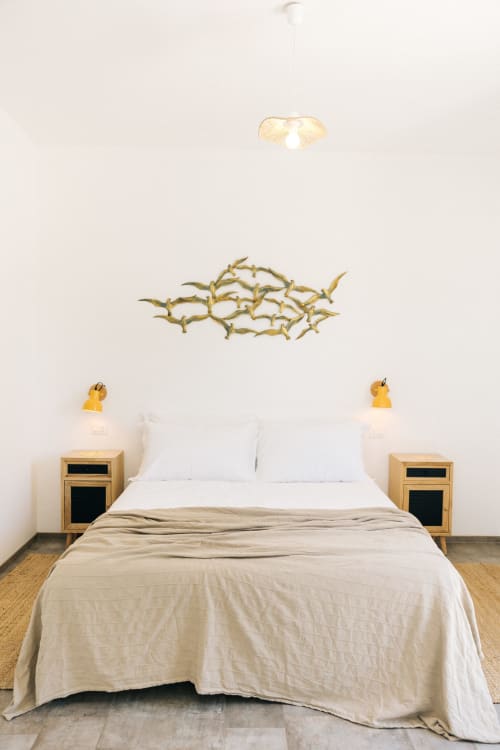 Camera da letto moderna a Tenuta Fascianello con letto, comodini, lampada a sospensione e decorazione murale con rami