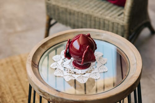 Candela decorativa rossa con centrino in pizzo su tavolo specchiato presso Tenuta Fascianello, Fasano