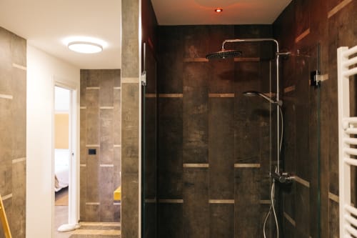 Bagno moderno con doccia rivestita in scuro, soffione pioggia e scaldasalviette a Tenuta Fascianello, Fasano