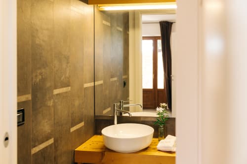 Moderno lavabo in ceramica bianca con piano di appoggio in oro presso l'hotel Tenuta Fascianello a Fasano