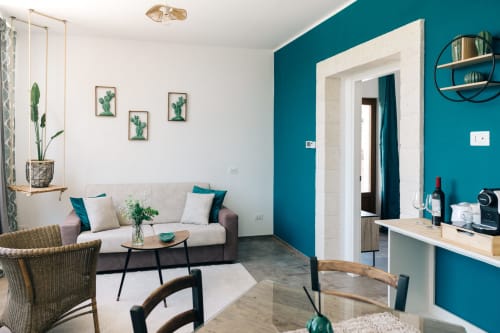 Elegante living room della Tenuta Fascianello a Fasano con parete azzurra, comodi sedili e vista giardino