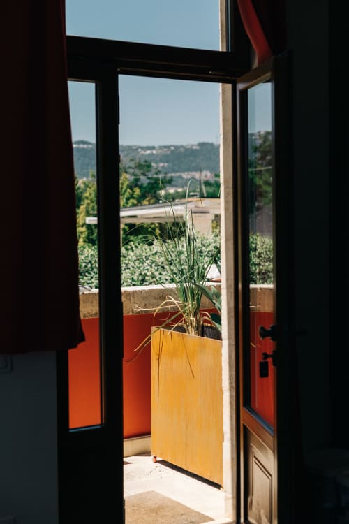 Porte finestre aperte su una soleggiata terrazza con piante in vaso e vista panoramica sulla campagna di Fasano a Tenuta Fascianello