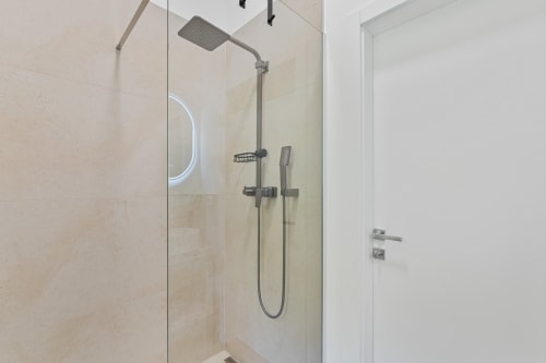 Douche moderne avec paroi vitrée, pomme de douche pluie et douchette à main à l'hôtel Mattbnb Ankoni Stay, Metz