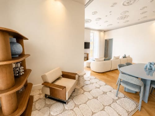 Zona living moderna nella Suite Ingrid di Seven Suites Sanremo con mobili in legno, sedute color crema e pavimenti in legno massiccio