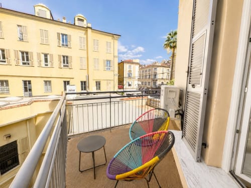 Sedie colorate intrecciate sul balcone con vista sul panorama di Sanremo, appartamento SEVEN SUITES SANREMO