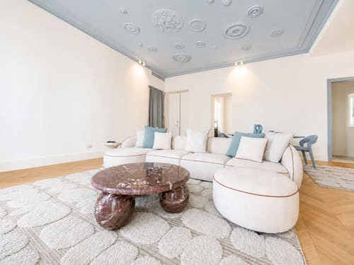 Soggiorno Suite Ingrid presso Seven Suites Sanremo con divano bianco curvo, tavolino in marmo e pavimenti in legno