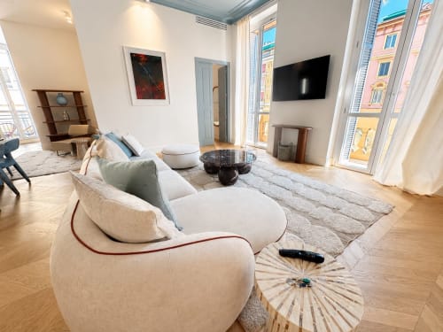 Soggiorno della Suite Moderna Ingrid presso SEVEN SUITES SANREMO con divano curvo, TV schermo piatto e vista sulla città dal balcone