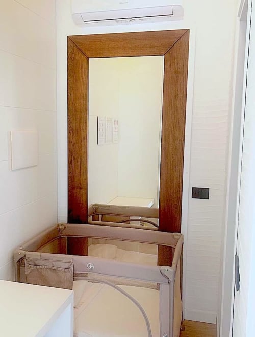 Mobile da bagno con specchio incorniciato in legno e lavabo in camera d'hotel Like at Home Palau, Sardegna