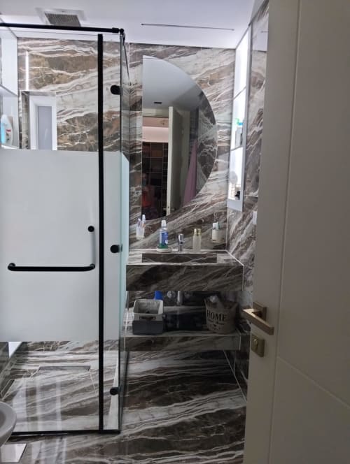 Bagno moderno con rivestimenti in marmo, box doccia in vetro e lavabo nella Gold Suite dell'Affittacamere Rozzano, Sharm El