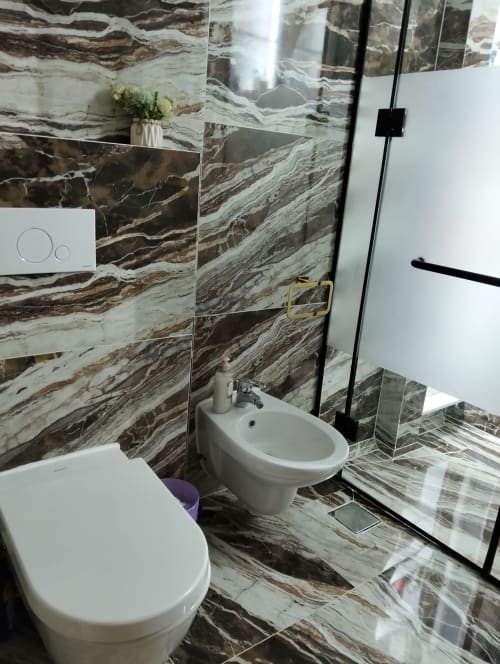Moderno bagno della Gold Suite presso Affittacamere Rozzano, Sharm el Sheikh, con piastrelle a motivo marmoreo, wc bianco e bidet