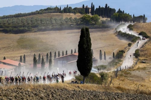 Tuscan countryside villa with cypress trees and dusty road near Buonconvento, Siena