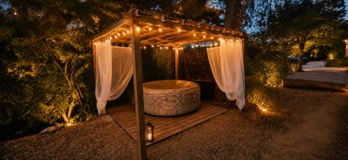 Pavillon de jardin illuminé aux rideaux drapés à la Bastide la Mourelette, Toulon, avec terrasse en bois et éclairage ambiant