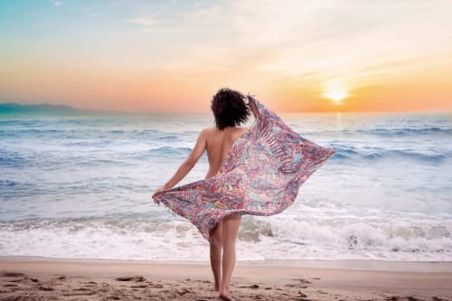Femme en sarong coloré admirant le coucher de soleil sur la plage de Cap d'Agde, Agde Luxury Loc