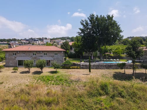 Quinta de Carvalhal Casa da Vinha em Guimarães com casa de pedra, jardim bem cuidado, árvores e piscina