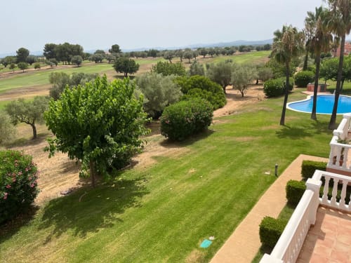 Vista exuberante del jardín, campo de golf, piscina y terrazas del apartamento Sant Jordi cerca de la playa