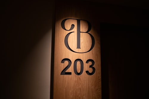 Puerta de madera de la habitación 203 del Hotel Bruna con números iluminados en Esterri d'Àneu