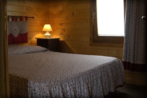 Camera accogliente con pareti in legno, letti gemelli e luce calda nella suite Casa Civetta di Country House Bosco d'Olmi