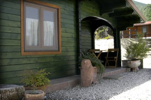 Ingresso dell'appartamento Casa Civetta a Bosco d'Olmi con facciata in legno verde e vista sul giardino in Campania