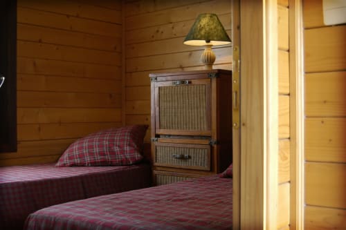 Cozy wooden bedroom at Casa Volpe, Country House Bosco d'Olmi, featuring red plaid bedding and rustic furniture