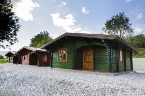 Green log cabin apartment Casa Istrice at Country House Bosco d'Olmi in Sant'Andrea del Garigliano, Italy, with gravel drive