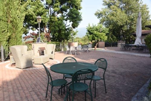 Garden terrace at Country House Bosco d'Olmi with dining table and lounge seating surrounded by trees
